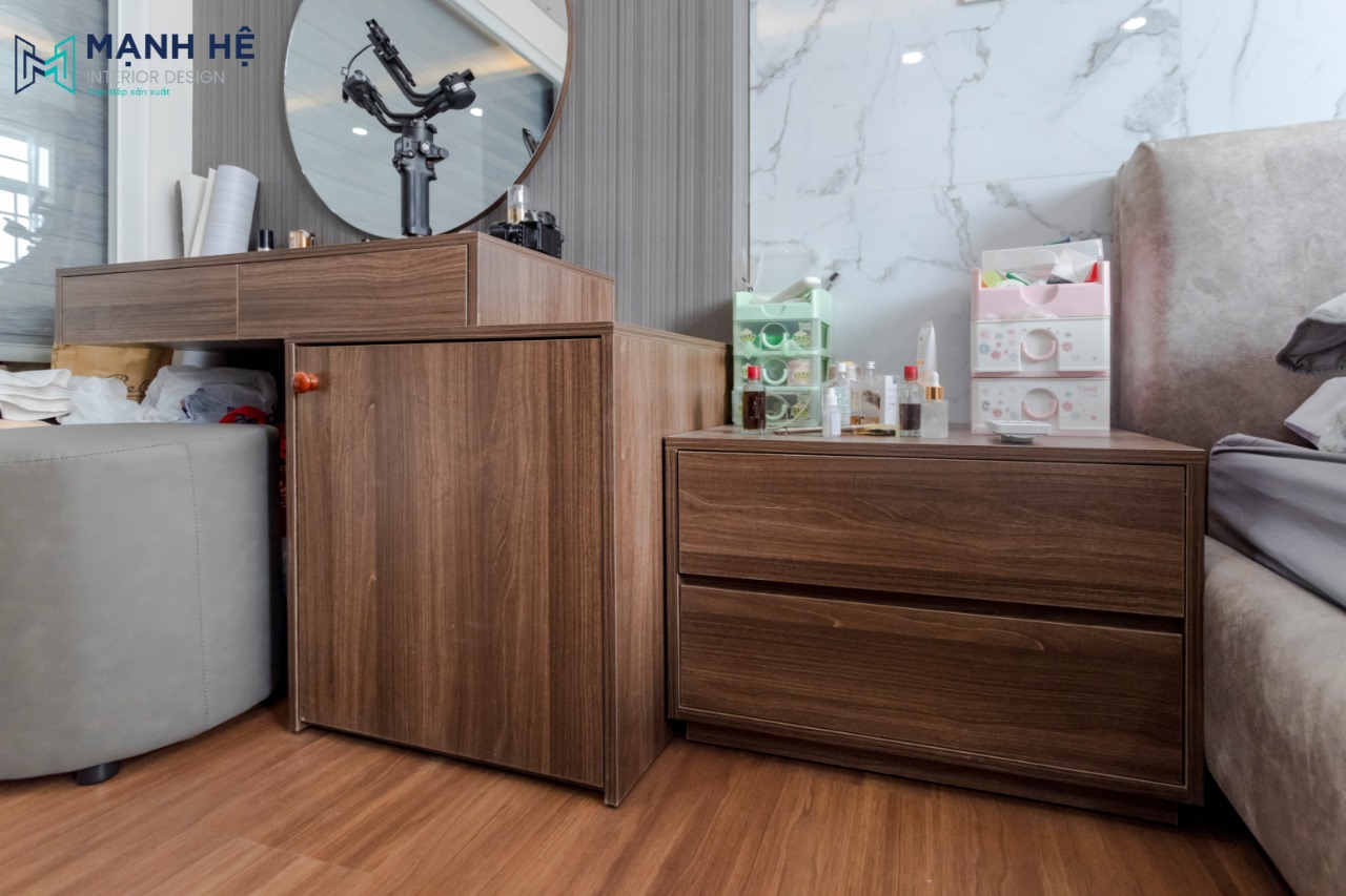 Bàn trang điểm và tab đầu giường được làm bằng gỗ công nghiệp đồng bộ với không gian phòng ngủ