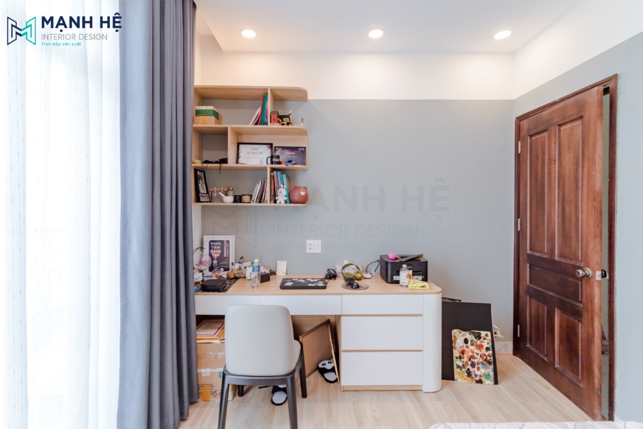 Bàn học và kệ sách treo tường được bố trí gọn ở 1 góc tường
