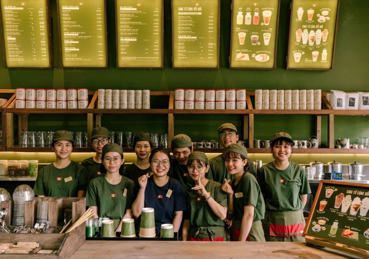 Đồng phục nhân viên gần trùng với màu sắc chủ đạo trong quán cafe