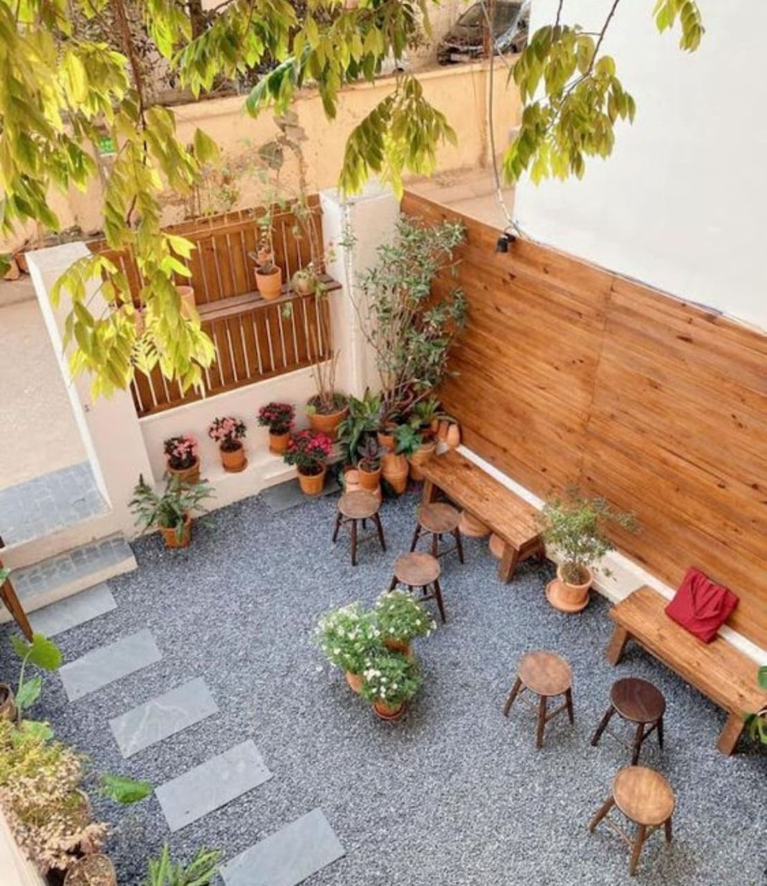 Ý tưởng 10: Trang trí quán cafe sân vườn bằng bàn ghế và tưởng gỗ kết hợp các chậu hoa nhỏ