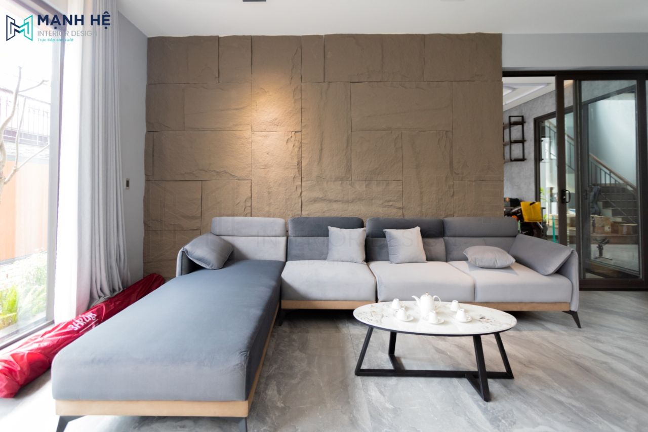 Phòng khách sử dụng bộ ghế sofa nỉ kết hợp với chiếc bàn trà tròn chân sắt hiện đại thu hút