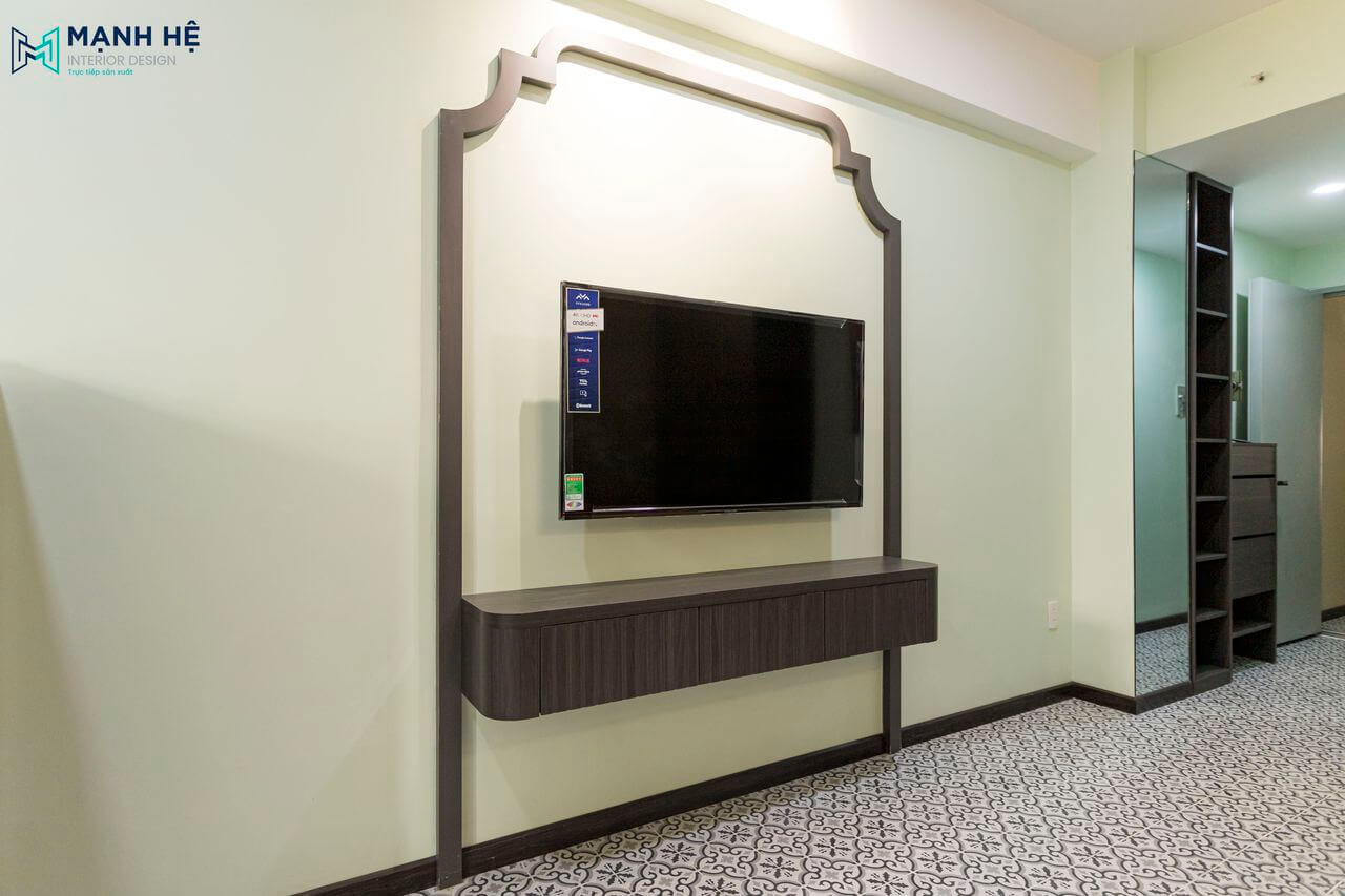 Kệ tivi treo tường được thi công với kiểu dáng hiện đại bo tròn hai bên góc, cùng khung đường viền thạch cao uốn lượn mềm mại