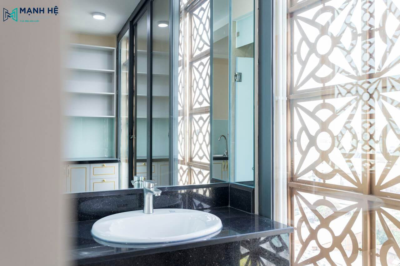 Khu vực vệ sinh bồn rửa được thi công ốp đá tự nhiên mang lại sự hiện đại và sạch sẽ, cửa sổ lớn tối ưu ánh sáng tự nhiên cho không gian.