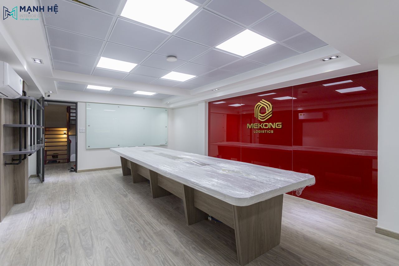 Phòng họp chung với tone màu trắng chủ đạo và vách ốp kính cường lực có màu đỏ cùng với logo nổi bật