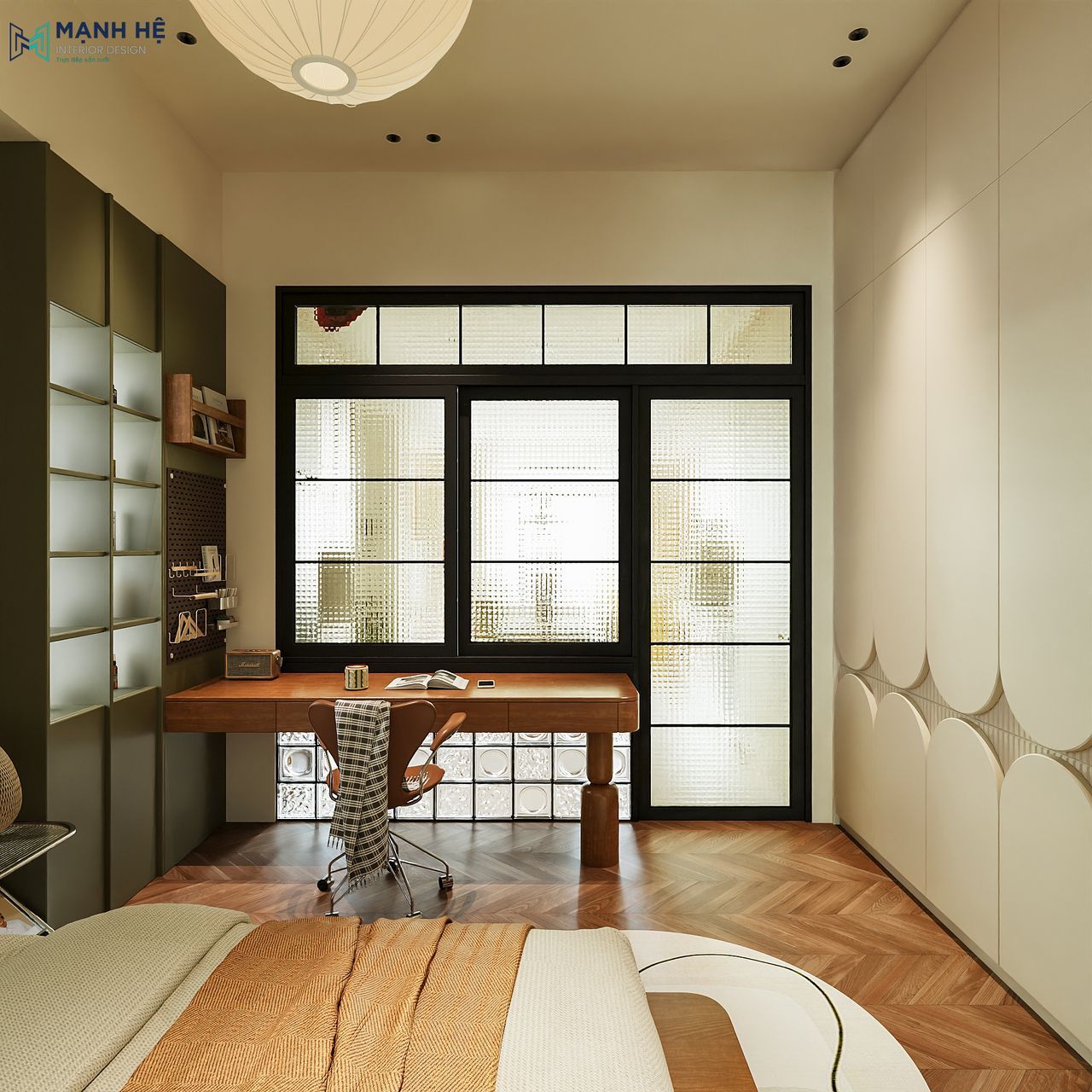 Bàn làm việc gỗ, tủ xanh olive và bảng ghim cạnh cửa kính trong phòng ngủ